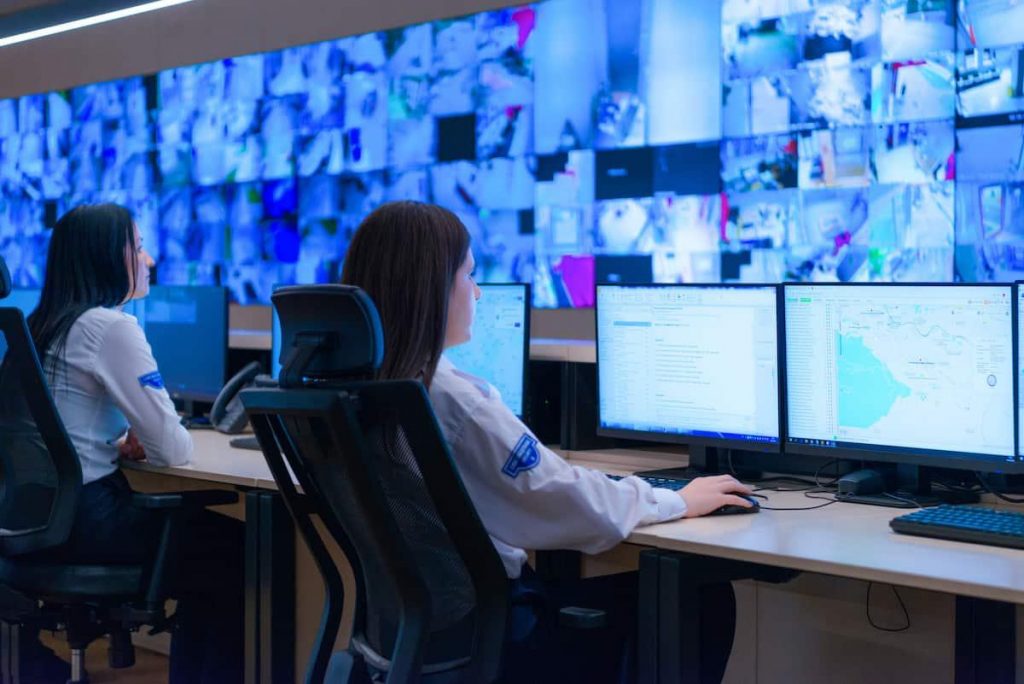 a group of people sitting at a desk with computers